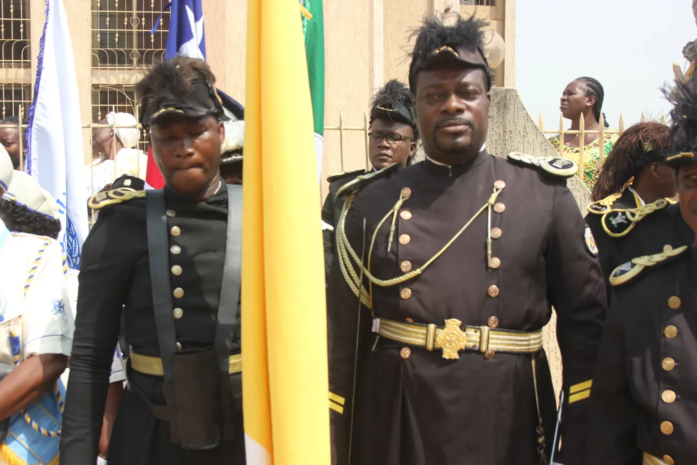 Membres en tenue cérémonielle auprès des drapeaux